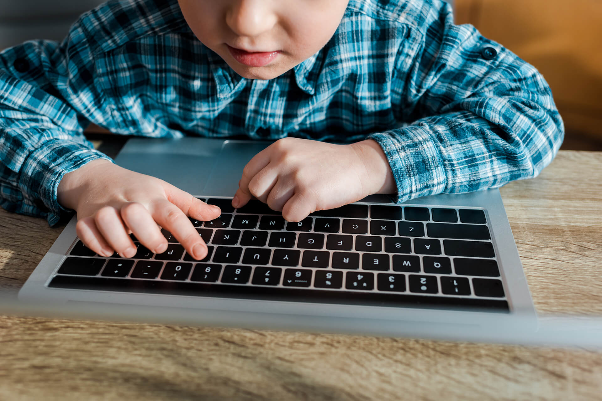 Child typing on laptop